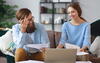 a man and a woman sitting at a table looking at pages of documents